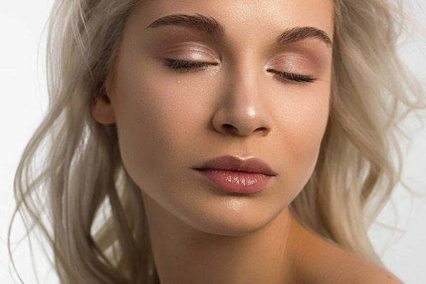 Closeup portrait of a woman with developing straight hair. Sweet tender young girl blonde. Natural lipstick, transparent clean skin. Skin care natural cosmetics in the spa salon or cosmetology. - Фото, зображення