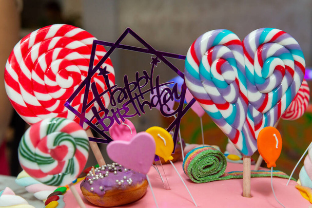 Buon compleanno torta con lecca-lecca e ciambelle
 - Foto, immagini