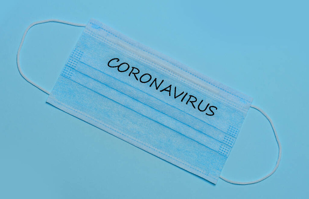 Surgical mask protective mask with CORONAVIRUS text. Chinese coronavirus outbreak. - Фото, изображение