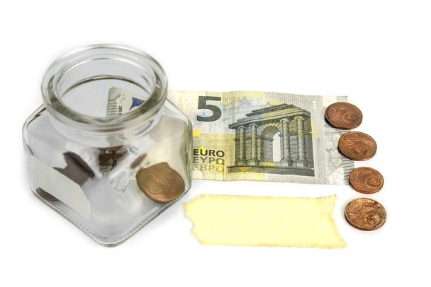 コインと銀行券が付いている空の瓶と空白のラベル。貯蓄概念 - 写真・画像
