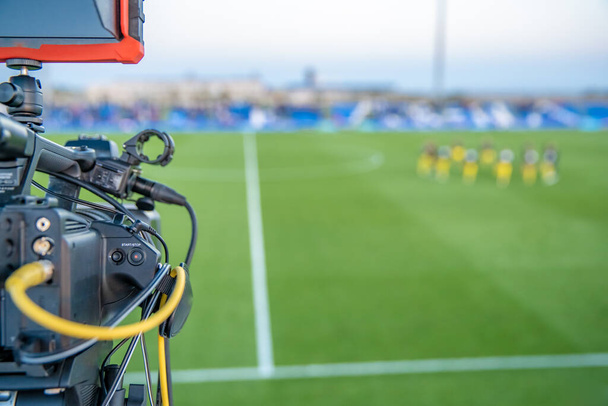 κάμεραμαν με κάμερα γυρίσματα βίντεο στο παιχνίδι ποδοσφαίρου - Φωτογραφία, εικόνα