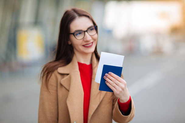 girl holds a passport near the airport. - Foto, Bild