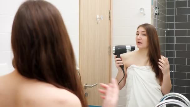 ενθουσιασμένοι νεαρή γυναίκα χορεύει και τραγουδά σε στεγνωτήρα μαλλιών - Πλάνα, βίντεο