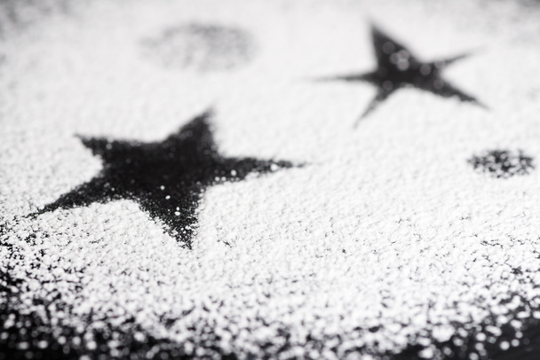 Estrella negra hecha con azúcar en polvo blanco
 - Foto, imagen