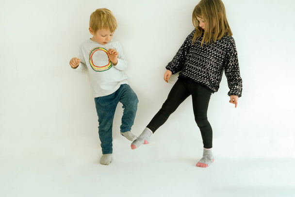足のタップで2人の子供の挨拶-ウイルスの拡散を避けるためにコロナウイルスcovid-19パンデミック発生時の新しい挨拶の概念 - 写真・画像