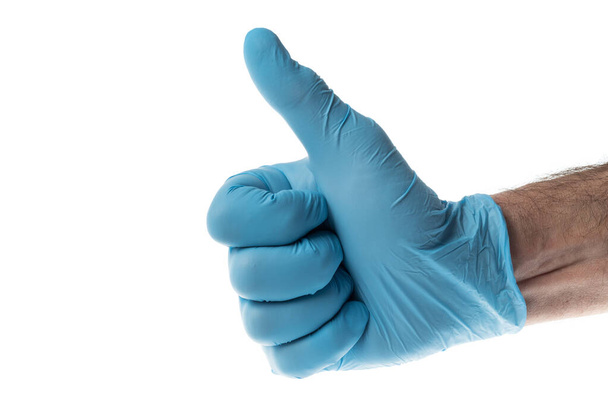 Kciuki do góry dłonią w niebieskiej rękawiczce lateksowej, odizolowane na biało - Zdjęcie, obraz