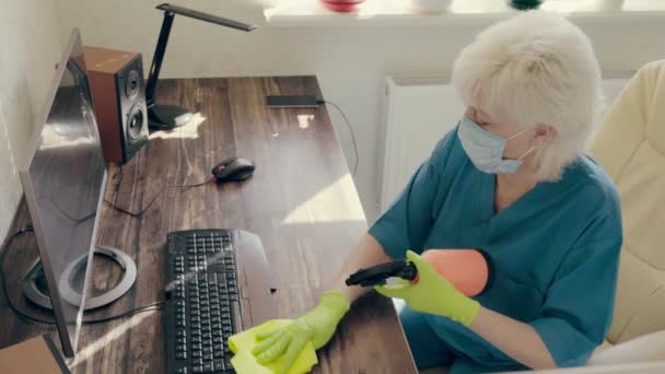 Mujer desinfectando una estación de trabajo de oficina
 - Imágenes, Vídeo