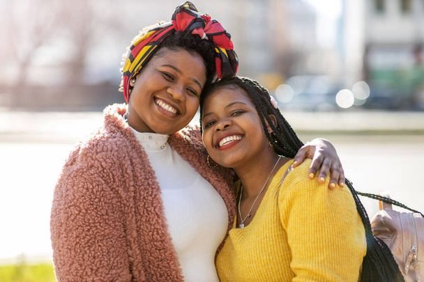 Дві вродливі афро - американські жінки, які разом бавляться у місті. - Фото, зображення