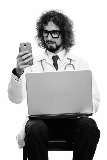 Студия снимок красивый бородатый мужчина врач с вьющимися волосами изолированы на белом фоне в черно-белом - Фото, изображение