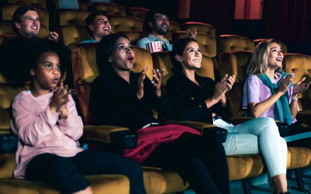 映画館で映画を見ている人たち。グループレクリエーション活動とエンターテイメントのコンセプト. - 写真・画像
