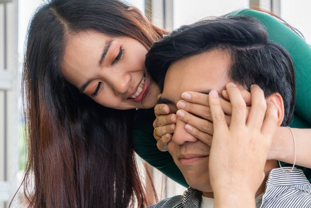 Happy Asian couple play covering eyes in living room. - Φωτογραφία, εικόνα