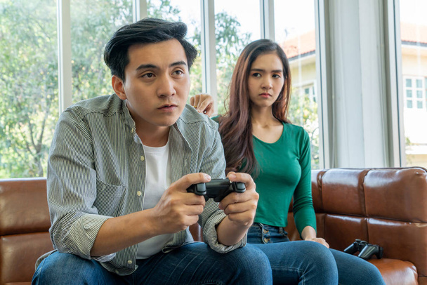 Νεαρό ζευγάρι Ασιατών πάσχει από εθισμό στα ηλεκτρονικά παιχνίδια. Οικογενειακό πρόβλημα. - Φωτογραφία, εικόνα