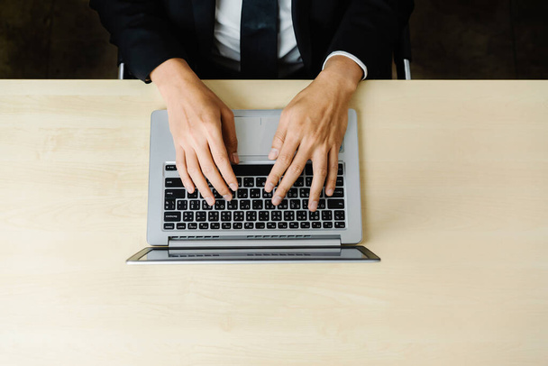 Бізнесмен або офісний працівник, використовуючи ноутбук, сидячи за столом
. - Фото, зображення