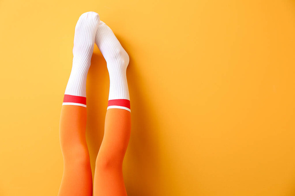Beine der jungen Frau in Socken und Strumpfhosen auf farbigem Hintergrund - Foto, Bild