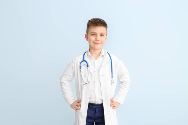 Cute little doctor on color background - Valokuva, kuva