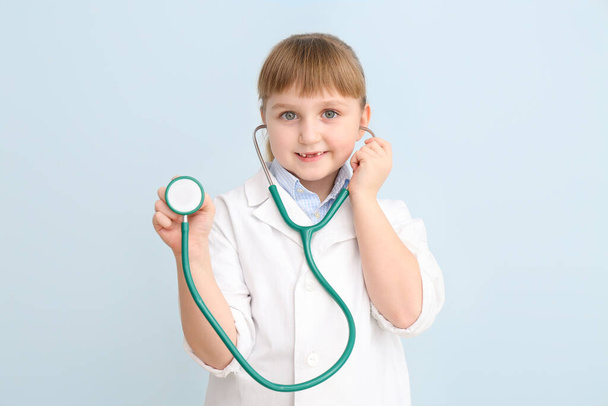 Cute little doctor with stethoscope on color background - Foto, Imagem