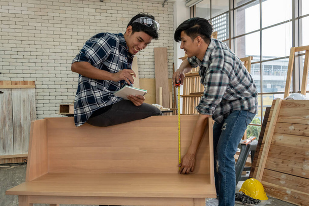 建設材料や木製の家具を生産するためにワークショップで木工に取り組んで大工。若いアジアの大工は作るための専門的な用具を使用する。DIYメーカーと大工仕事のコンセプト. - 写真・画像