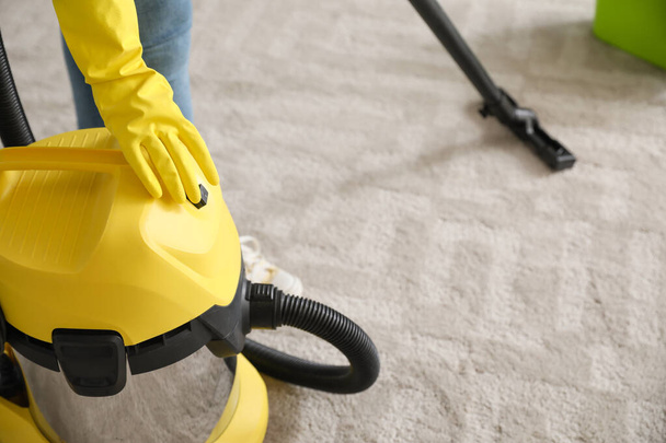 Young woman hoovering floor at home - Photo, Image