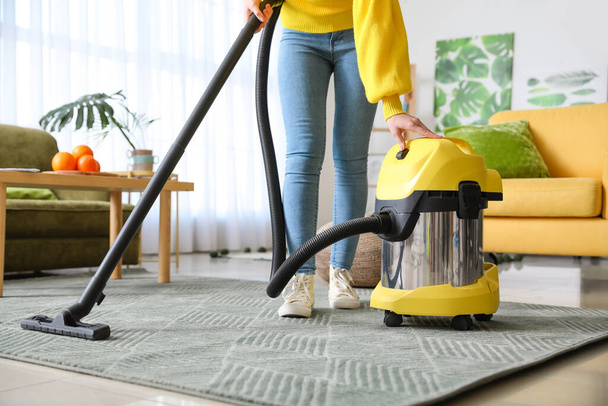 Mladá žena vysávání podlahy doma - Fotografie, Obrázek