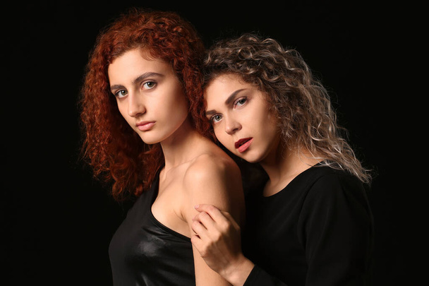 Beautiful young women on dark background - Фото, изображение