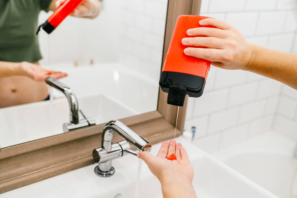 Coronavirus-Prävention Körperpflege. Spezielle Flüssigseife zum Händewaschen, Frau im Badezimmer. - Foto, Bild