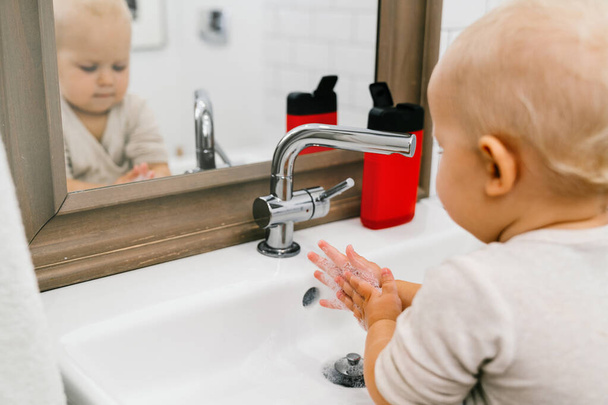 Dítě si nezávisle myje ruce v koupelně. Prevence infekčních onemocnění, chřipky a koronaviru. - Fotografie, Obrázek