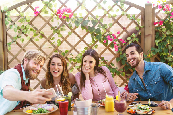 Ευτυχισμένοι φίλοι που βγάζουν selfie με κινητό smartphone ενώ γευματίζουν στο εστιατόριο του καφέ brunch - Νέοι μοντέρνοι άνθρωποι που διασκεδάζουν τρώγοντας μαζί - Youth tech lifestyle food culture concept - Φωτογραφία, εικόνα