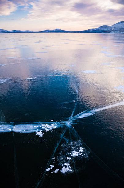 Hielo en el lago congelado al atardecer. Hermoso paisaje de invierno
. - Foto, Imagen