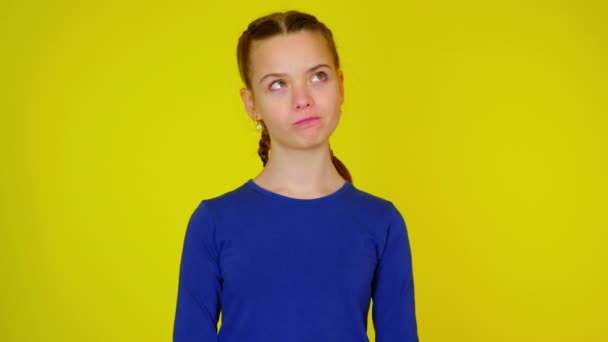 tiener meisje in blauw pullover is op zoek naar plaats voor tekst en denkt - Video