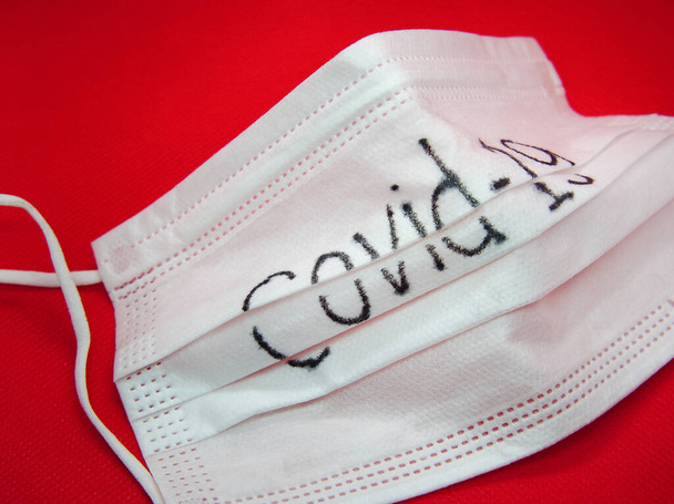 Corona virus Covid-19, Primer plano de la máscara médica sobre un fondo rojo.  - Foto, Imagen