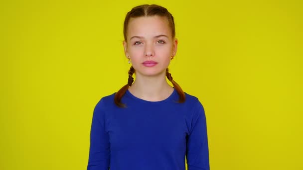 Glückliches Teenie-Mädchen in blauem Pullover posiert, lacht und blickt in die Kamera - Filmmaterial, Video