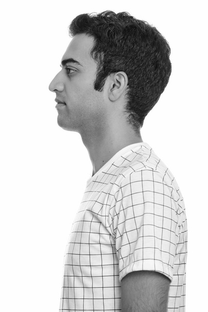 Studio shot of young Persian man isolated against white background in black and white - Foto, Imagen