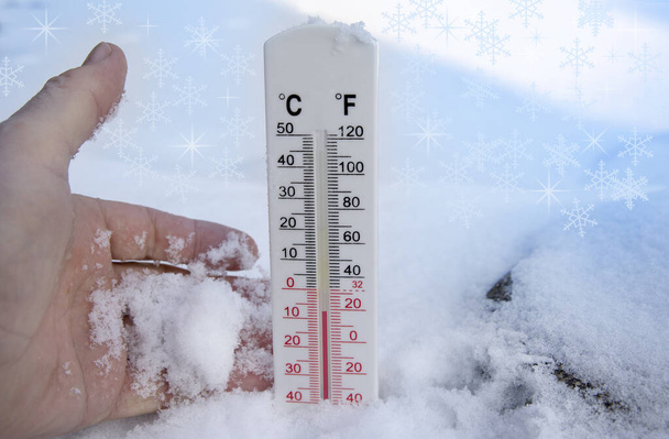 A hóban lévő hőmérő fagyos hőmérsékletet mutat Celsiusban vagy Farenheitben. - Fotó, kép