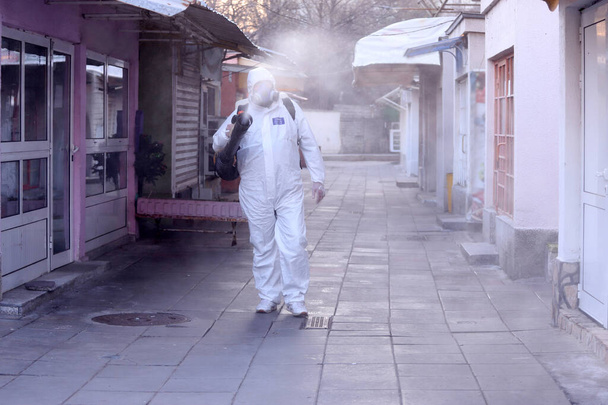 Spraying, disinfection and decontamination on a public place as a prevention against Coronavirus disease 2019, COVID-19. State of emergency over coronavirus, quarantine - Photo, Image