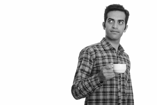 Studio shot of young Persian hipster man isolated against white background in black and white - Valokuva, kuva