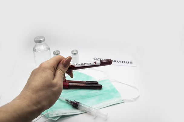Coronavirus blood test 2019-2020. Female hand holding test tubes with blood in laboratory. Concept can be used in the design - Foto, Imagen
