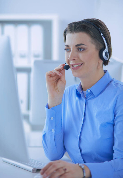 Serious pretty young woman working as support phone operator with headset in office - Φωτογραφία, εικόνα