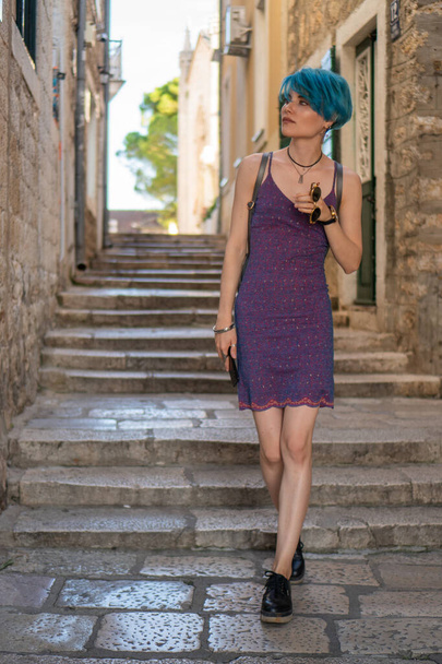Girl blogger in a purple dress walks the streets of the old city - Fotoğraf, Görsel