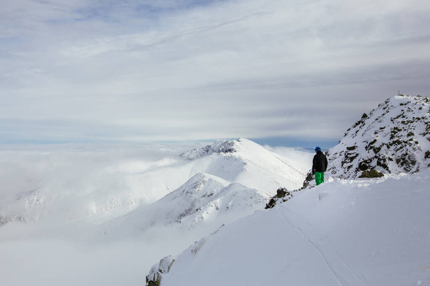 Hiihtäjät katselevat kaunista lumista maisemaa vuoren huipulta. Taustalla korkeat Tatra vuoret. Chopok-huippu, Low Tatras, Slovakia, Eurooppa
. - Valokuva, kuva