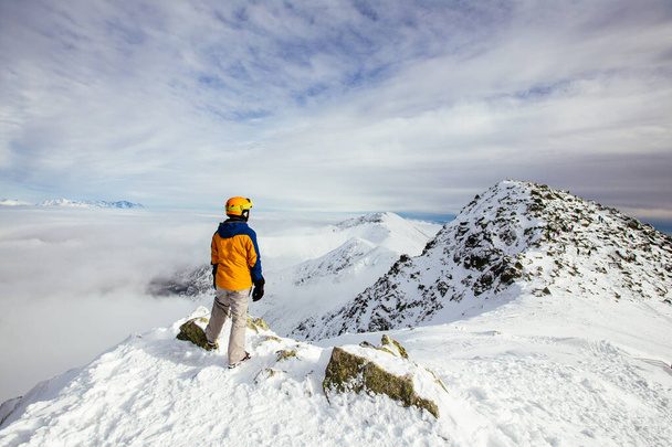 Esquiadores mirando el hermoso paisaje nevado desde la cima de la montaña. En el fondo las altas montañas de Tatra. Pico Chopok, Baja Tatras, Eslovaquia, Europa
. - Foto, Imagen
