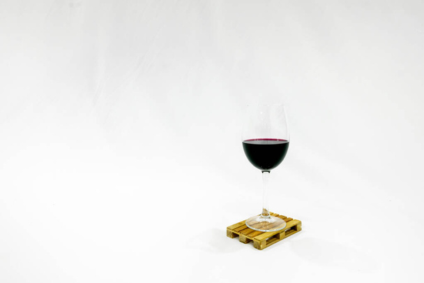 白を基調としたパレットにはワインのグラスが置かれています。空白画像。ワインの配達と輸送. - 写真・画像