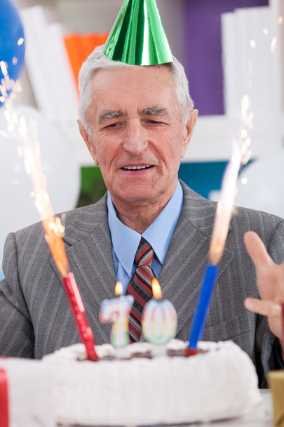 Excited senior man looking at his birthday cake - Foto, Imagen