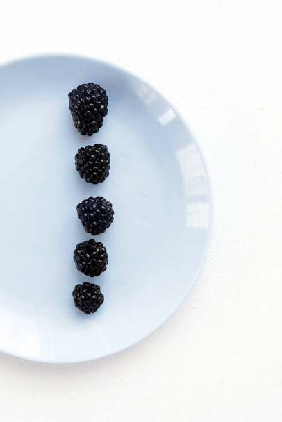 blackberries on a blue plate - Фото, зображення