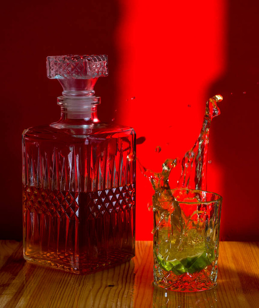  Carafe glass with a drink with lime, splashes - Photo, Image