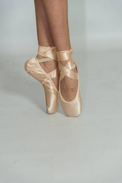 legs of a ballerina in a pointe shoes dancing on white background  - Φωτογραφία, εικόνα