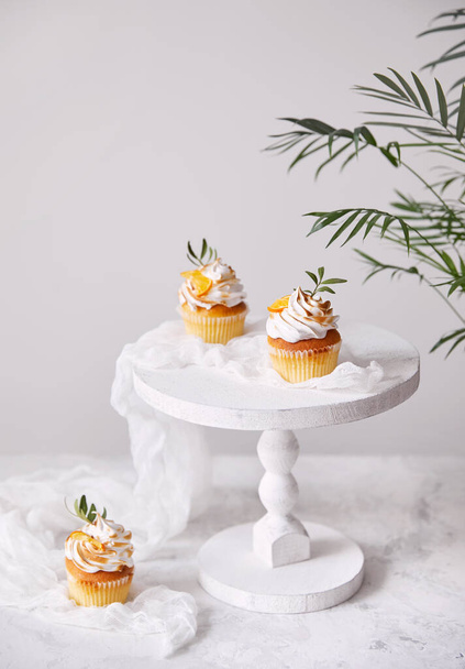 Homemade cupcakes decorated with lemon and leaves on white background. Free space for your text   - Foto, afbeelding