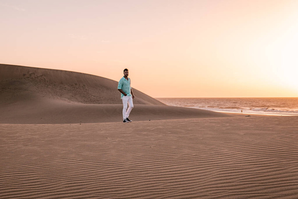guy walking at the beach of Maspalomas Gran Canaria Spain, men at the sand dunes desert of Maspalomas - Photo, Image
