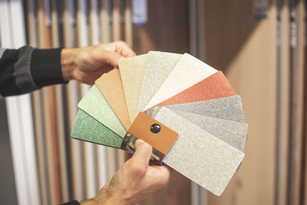 Man choosing the right colour and material of vinyl for his new apartment in floor studio, furnishing households - Photo, Image