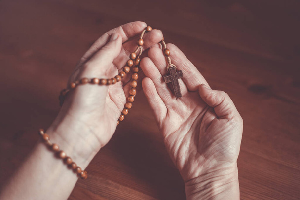 Молитва жінка тримає дерев'яний розарій в руці, концепція релігії
 - Фото, зображення