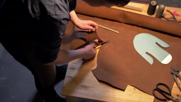Mies leikkaa kangaspalan pöydälle
 - Materiaali, video
